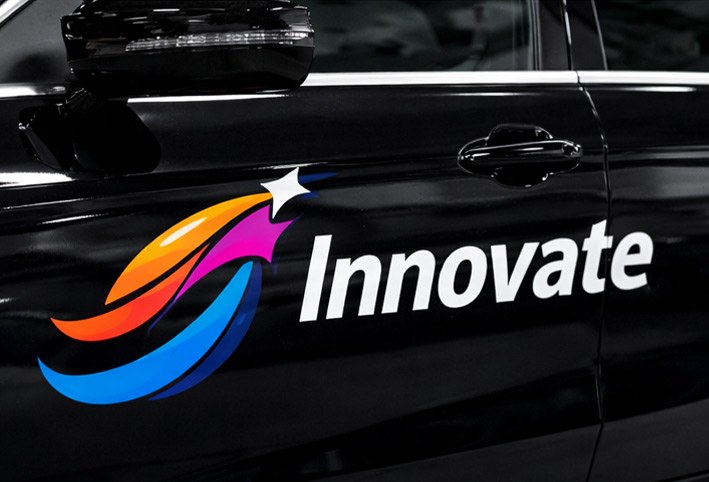 Vinilo impreso y recortado con forma de logo multicolor aplicado en la puerta lateral de un coche negro