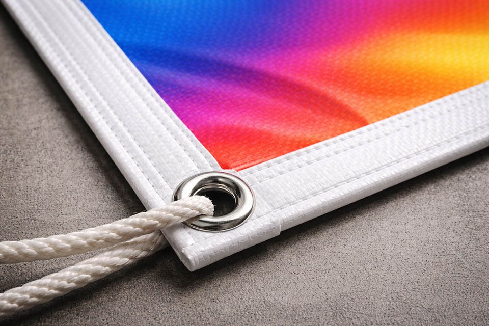 detalle de lona impresa barata con ollados y refuerzo perimetral